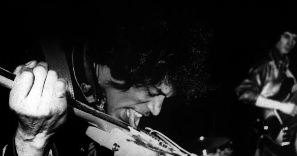 Jimi Hendrix playing the guitar with his teeth